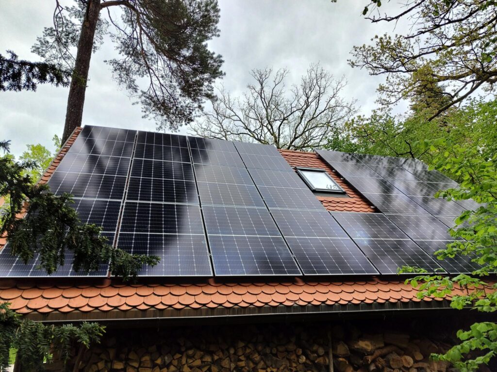 Photovoltaikanlage auf rotem Ziegeldach im Grünen