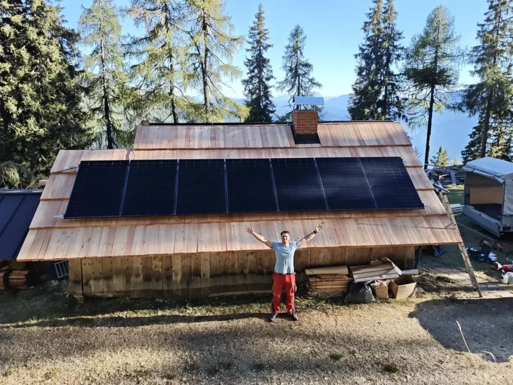 Andi vor der fertigen PV-Anlage auf dem neuen Holzdach der Scheune