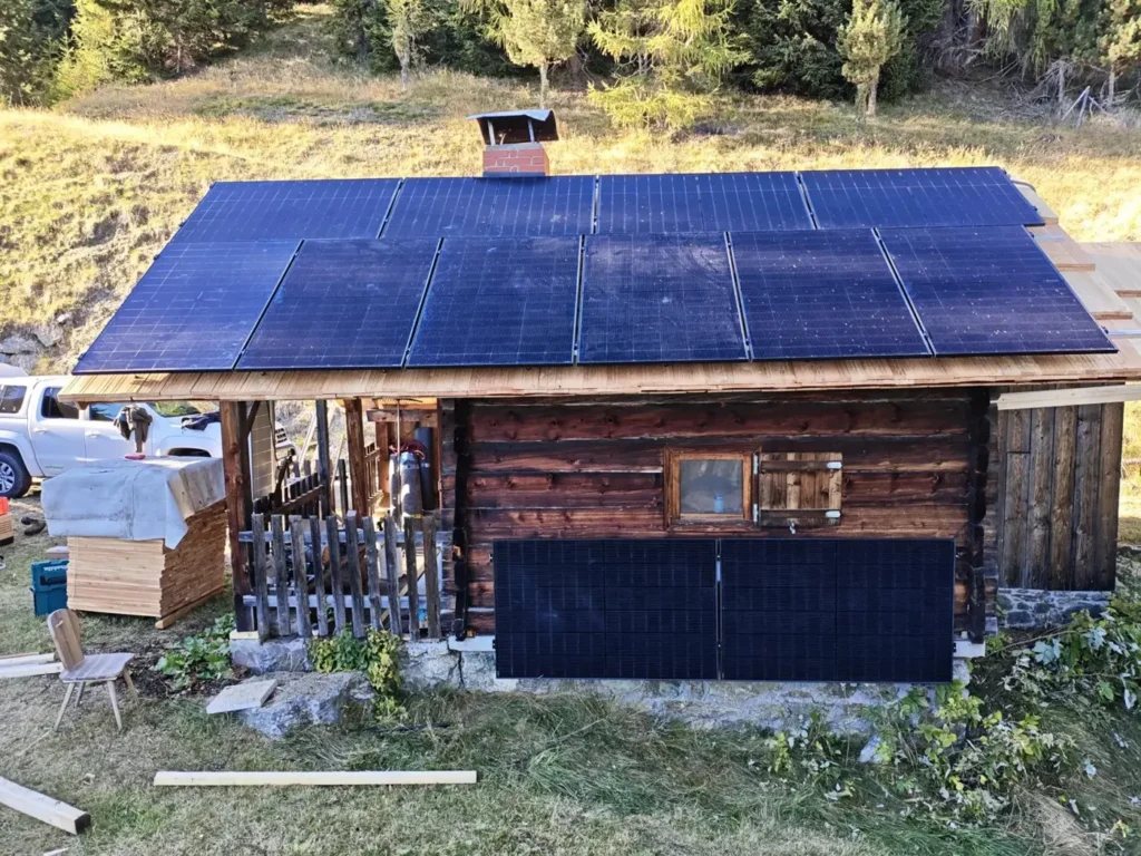 Berghütte mit Full-Black-PV-Modulen auf dem Dach und Balkonkraftwerk an der Fassade