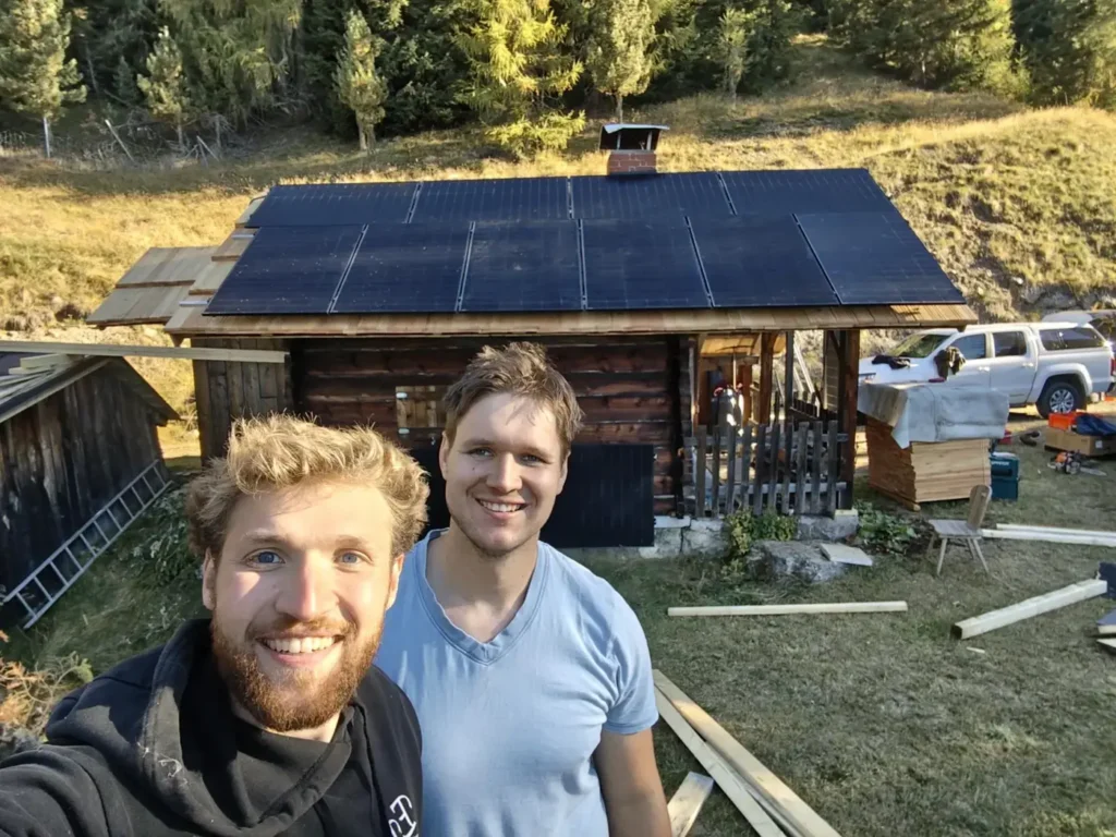 Michi und Andi vor der Berghütte mit Insel-PV-Anlage