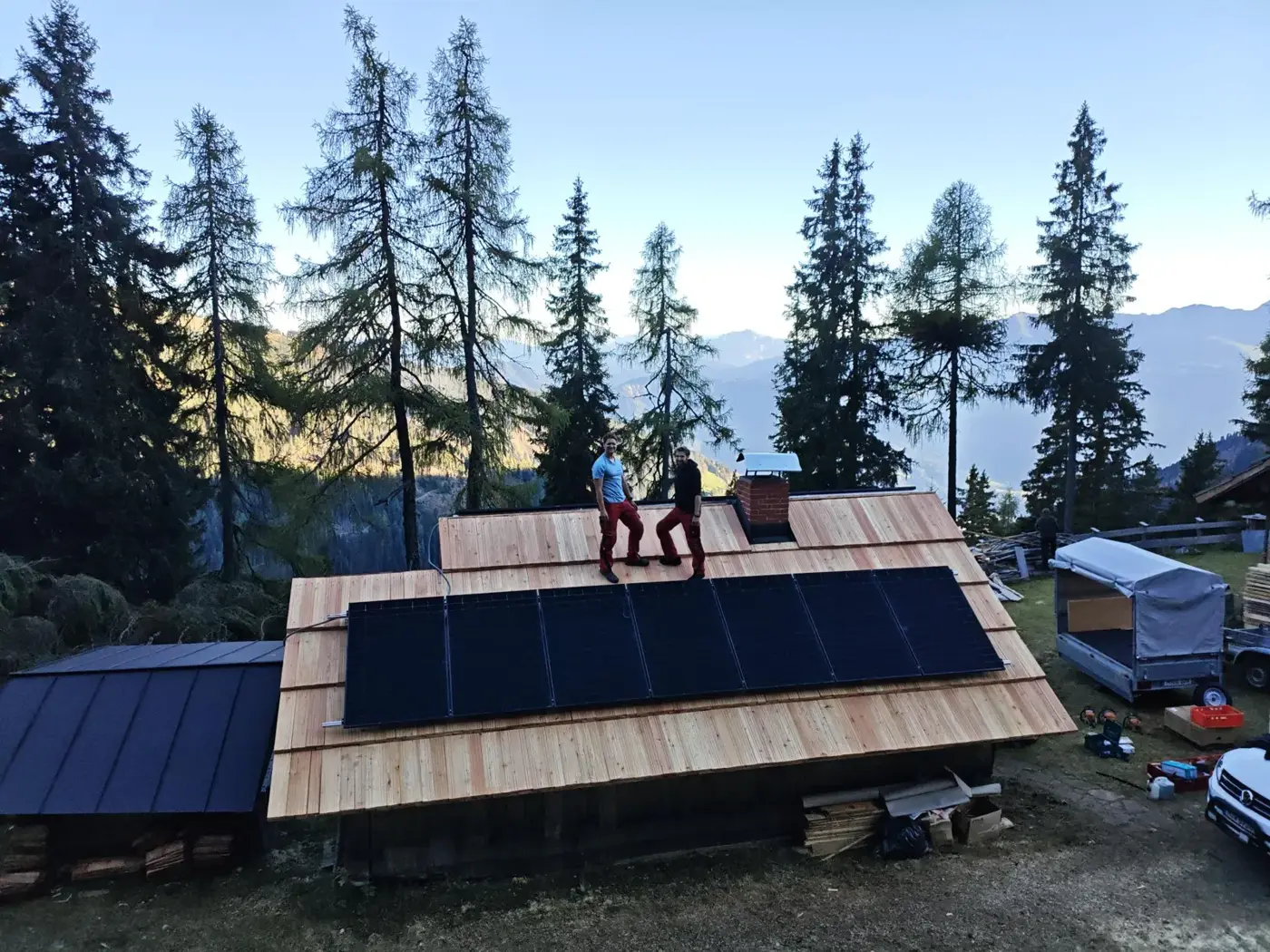 Michi und Andi auf dem Scheunendach mit PV-Modulen in den Alpen